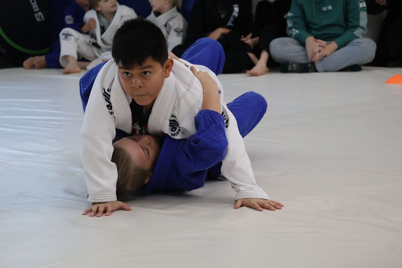 Teaching kids martial arts, particularly Brazilian Jiu-Jitsu, enhances their self-defense skills, physical training, and physical skills, while boosting self-confidence, life skills, hand-eye coordination, and the ability to learn new techniques and set goals, all with little resistance.
